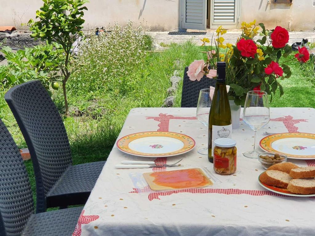 een tafel met een fles wijn en borden met eten bij Casa Vacanza Luca in Vulcano