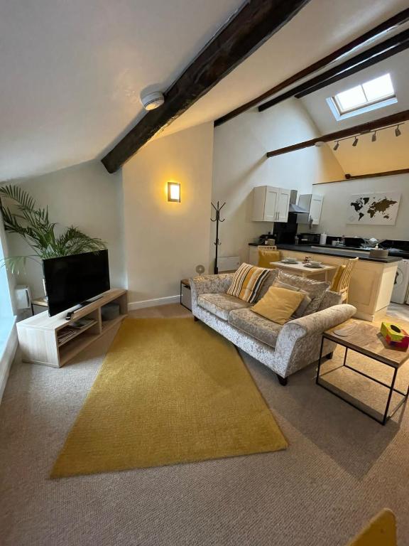 a living room with a couch and a tv at Flat 2 Chestergate in Macclesfield