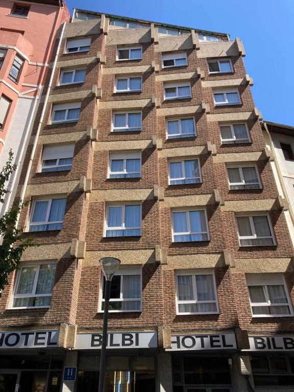 a tall brick building with a sign on it at Hotel Bilbi in Bilbao