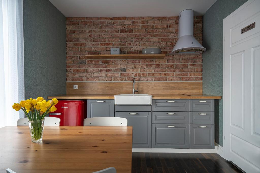 a kitchen with a wooden table and a brick wall at W Starym Porcie Krynica Morska in Krynica Morska