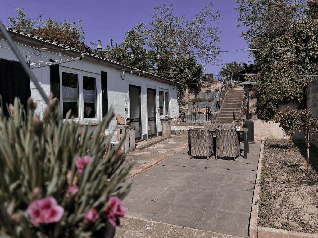 a house with two chairs and flowers in front of it at Loods 123 bed & kitchen in Landgraaf