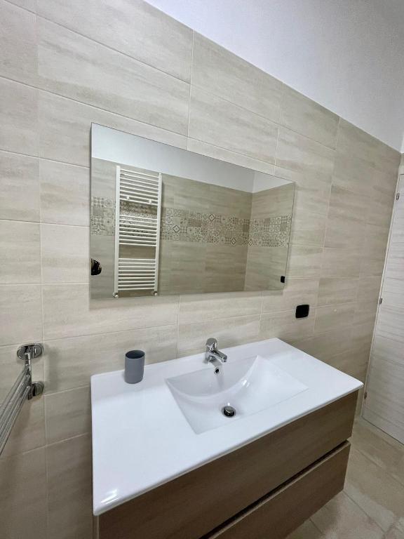 łazienka z białą umywalką i lustrem w obiekcie B&B La Piazzetta w mieście Fragagnano