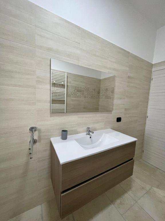 łazienka z umywalką i lustrem w obiekcie B&B La Piazzetta w mieście Fragagnano