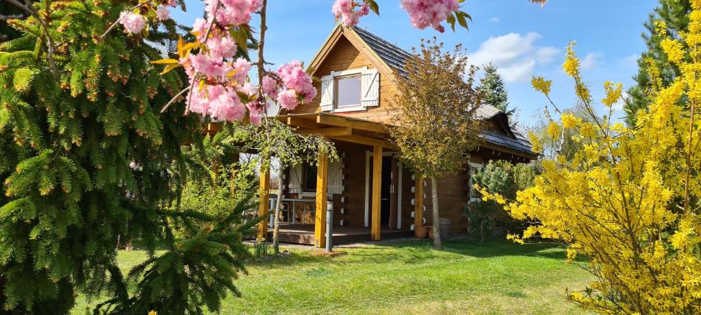 a cabin in the woods with pink flowers at Domek Mazury - Jezioro Orzysz in Orzysz