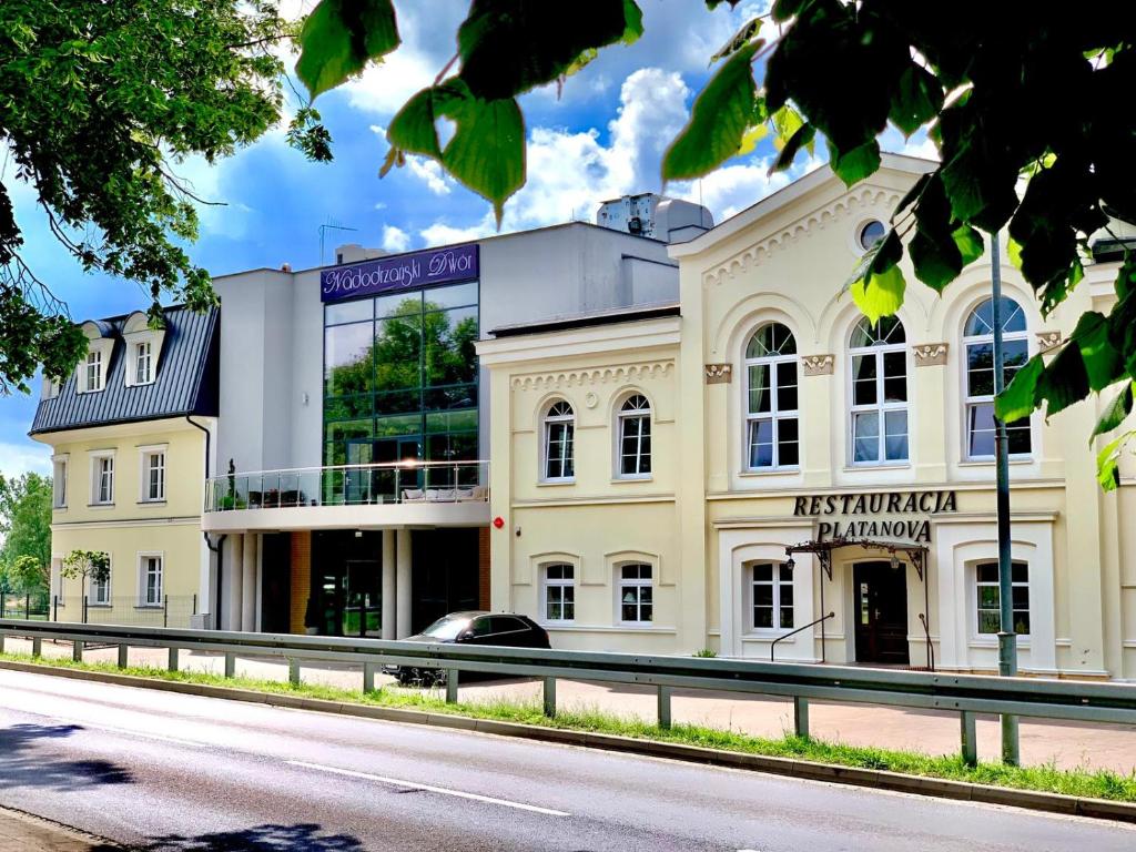 a large white building on the side of a road at Hotel Nadodrzański Dwór - Nowa Sól in Nowa Sól