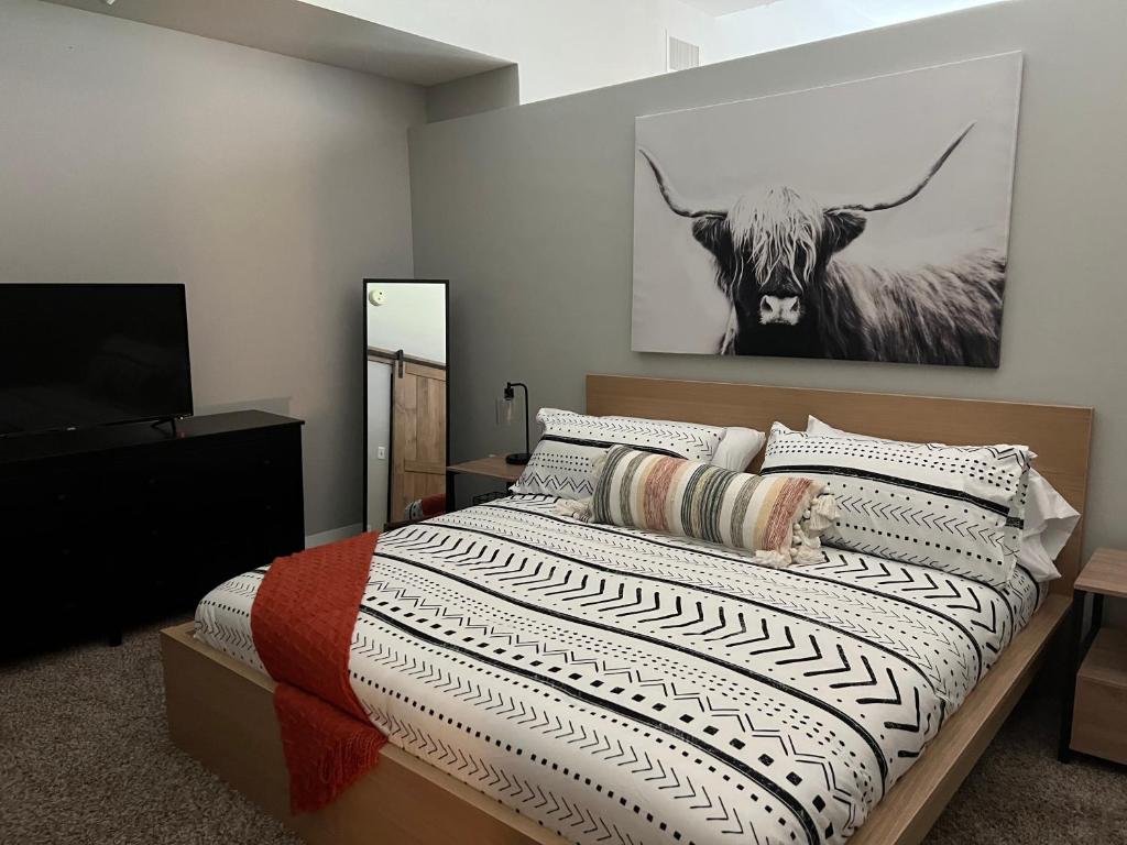 a bedroom with a bed with a cow on the wall at Downtown Norfolk Loft in Norfolk
