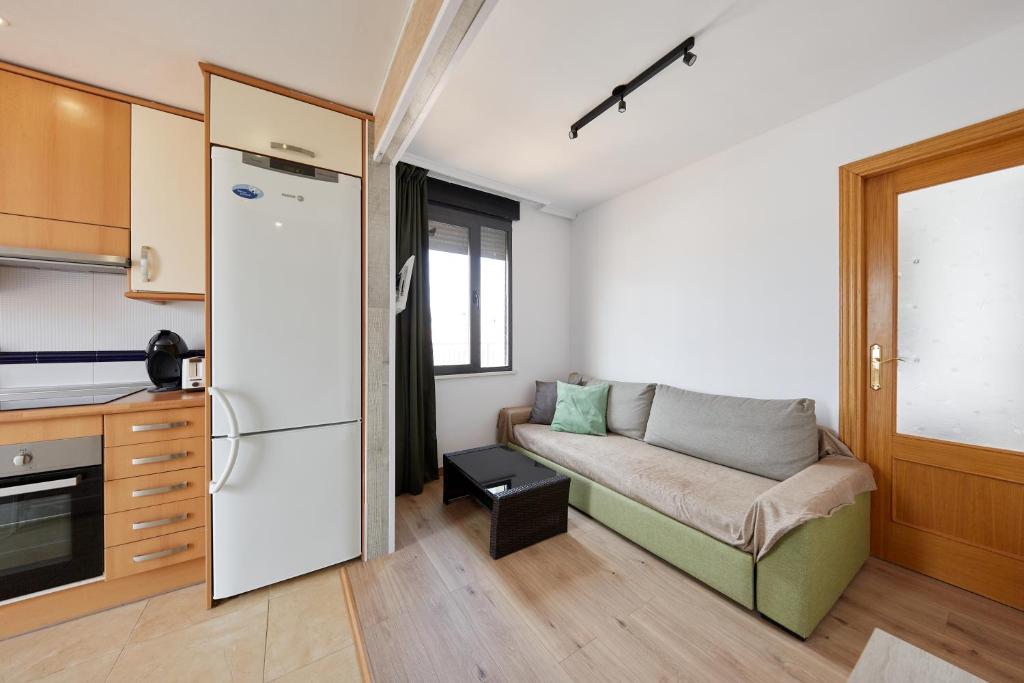a living room with a couch and a kitchen at Apartamentos Wayteko in Alicante