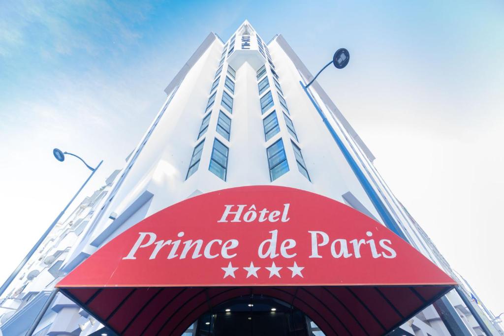 a hotel entrance with a red sign in front of a building at Prince de Paris in Casablanca