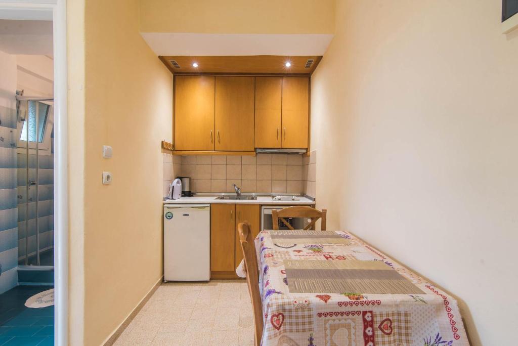 uma pequena cozinha com uma mesa e um lavatório em Bozikis Studios em Paleokastritsa