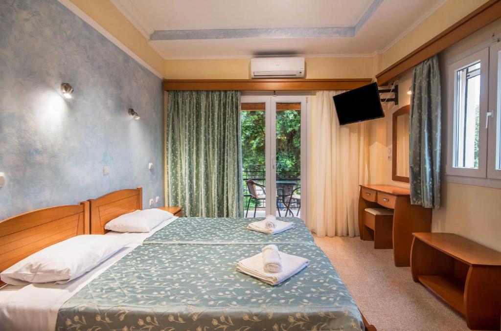 um quarto de hotel com uma cama e uma janela em Bozikis Studios em Paleokastritsa