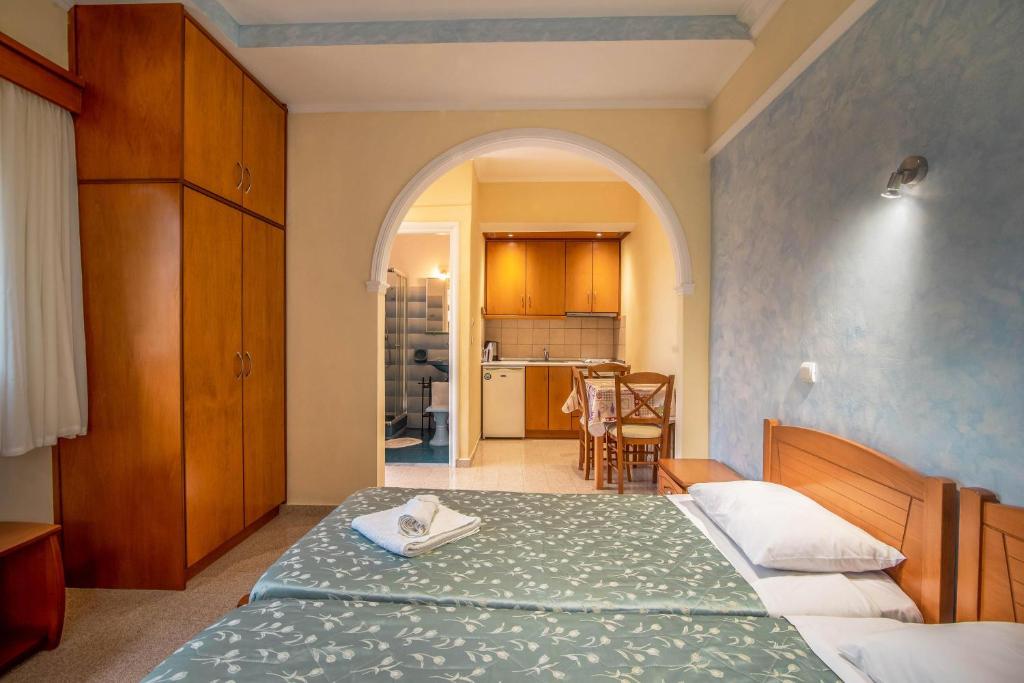 um quarto com uma cama e uma cozinha com uma mesa em Bozikis Studios em Paleokastritsa