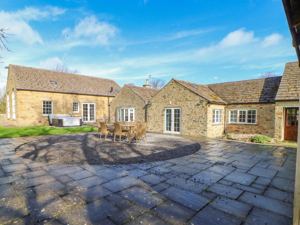 una casa in pietra con un patio di fronte di Burns Cottage a Barnard Castle