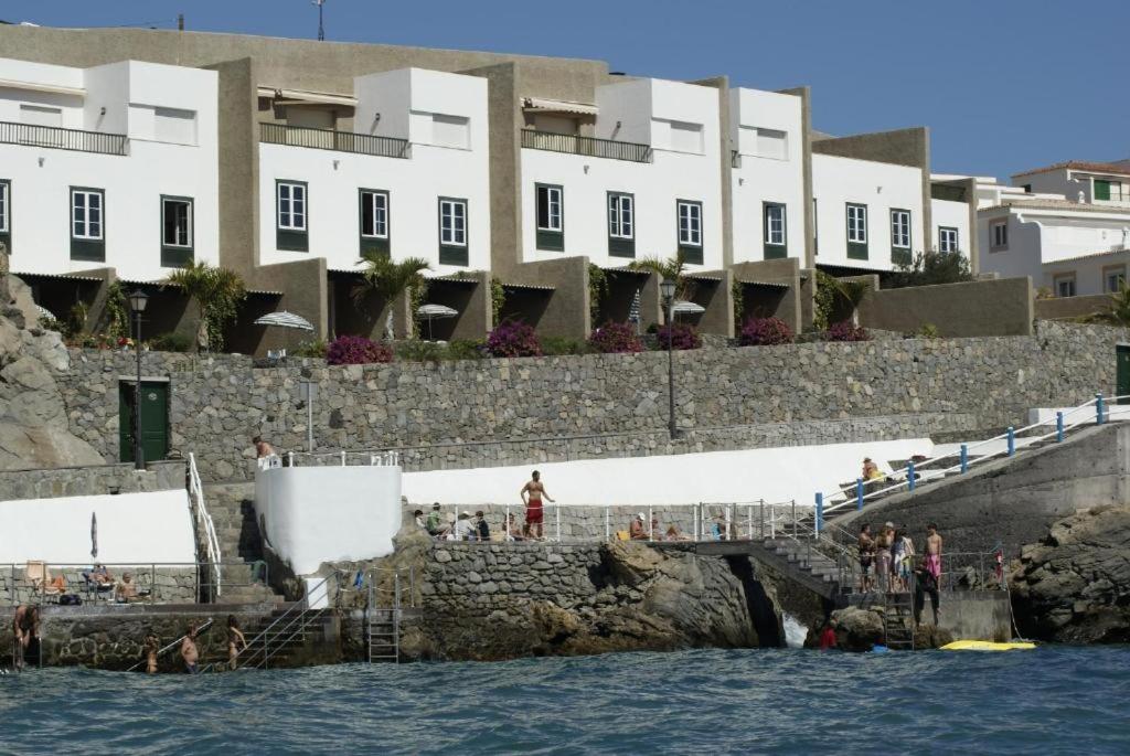a group of people standing on the stairs near the water at Apartamentos Alegro in Poris de Abona