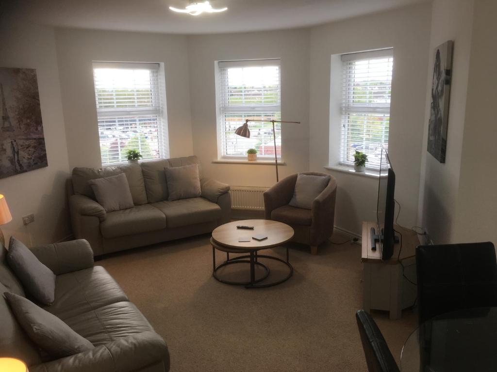 una sala de estar con un sofá y una mesa en Beautiful 2 bed apartment, en Grantham