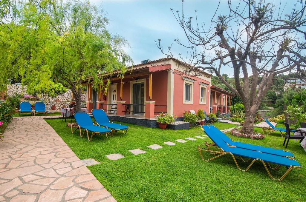 uma casa com cadeiras azuis no quintal em Bozikis Studios em Paleokastritsa