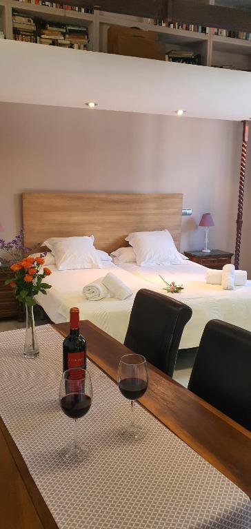 a room with two beds with wine glasses on a table at Apartamentos Torre de la Mezquita in Córdoba