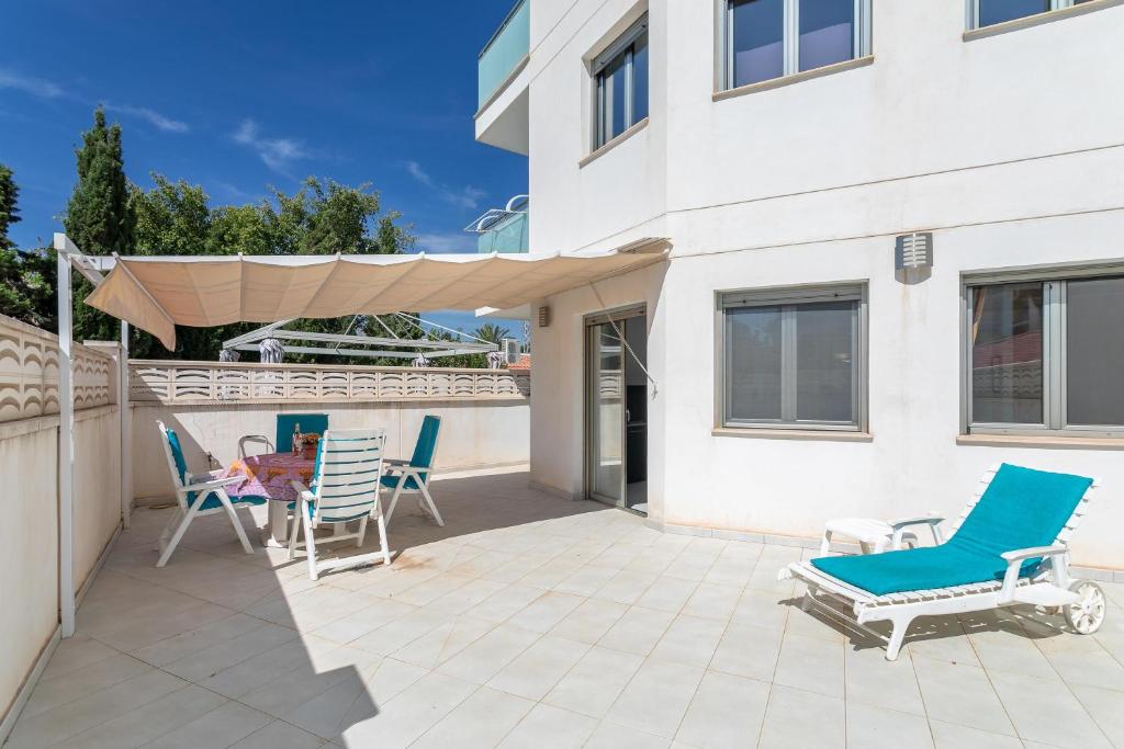 une terrasse avec des chaises, une table et un parasol dans l'établissement Apartment Henri, à El Campello