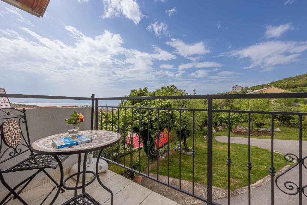 a balcony with a table and a view of a yard at Apartments Klara in Senj