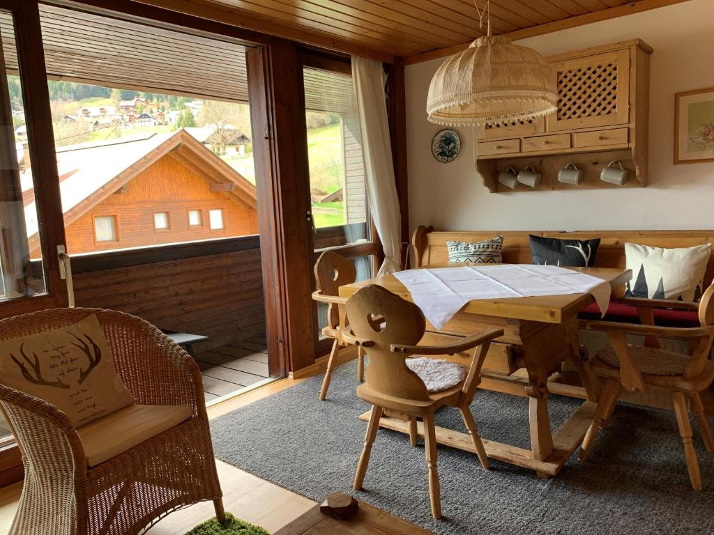 d'une salle à manger avec une table, des chaises et une fenêtre. dans l'établissement Ski und Therme 1, à Bad Kleinkirchheim