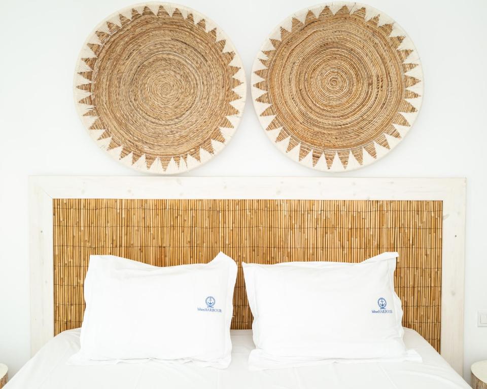 a bedroom with two white pillows and two hats on the wall at Blue Harbour Boutique in Ayia Napa