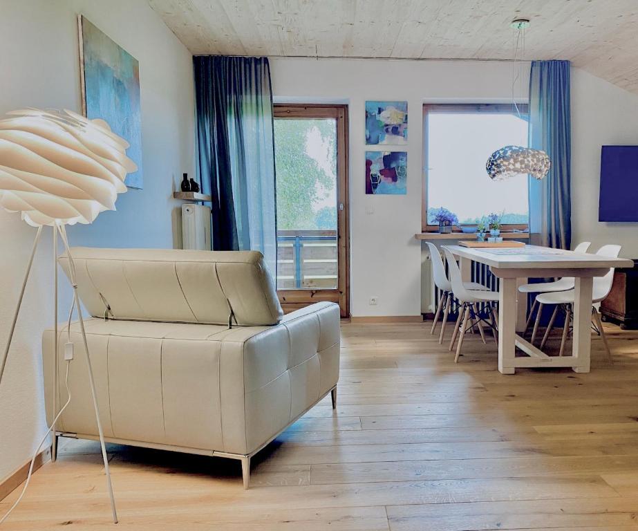 uma sala de estar com um sofá e uma mesa em Ferienwohnung ChiemseeAlpenBlick em Breitbrunn am Chiemsee