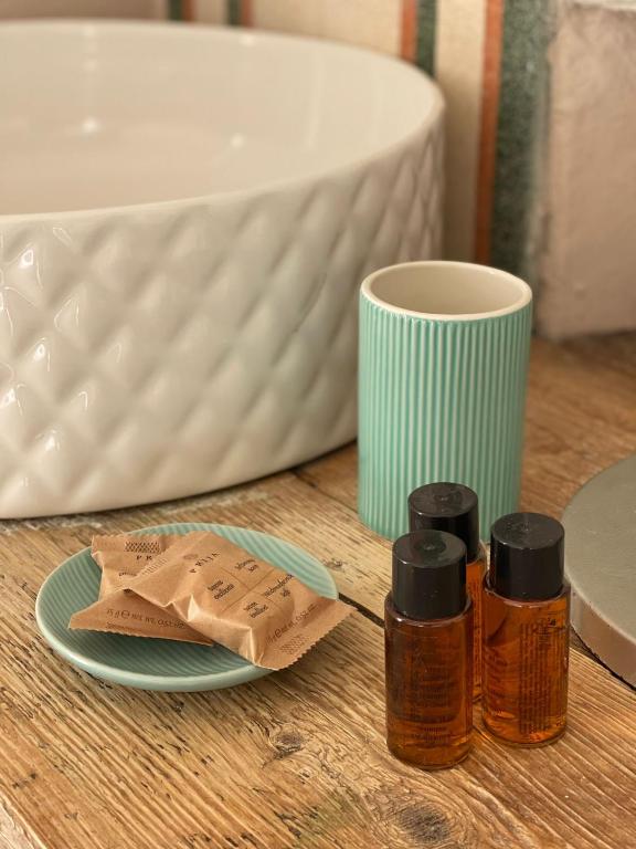 a table with three bottles of essential oils and a cup at Locanda Garzelli in Quercianella
