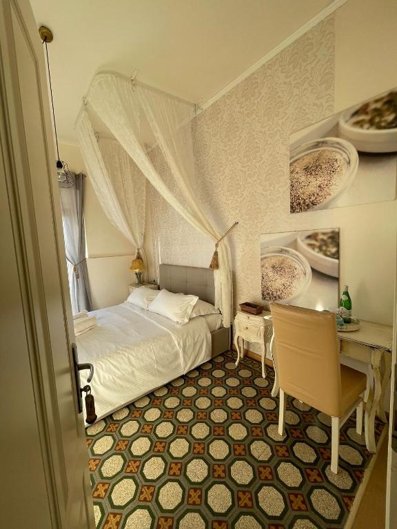 a bedroom with a bed and a table with a chair at Locanda Garzelli in Quercianella