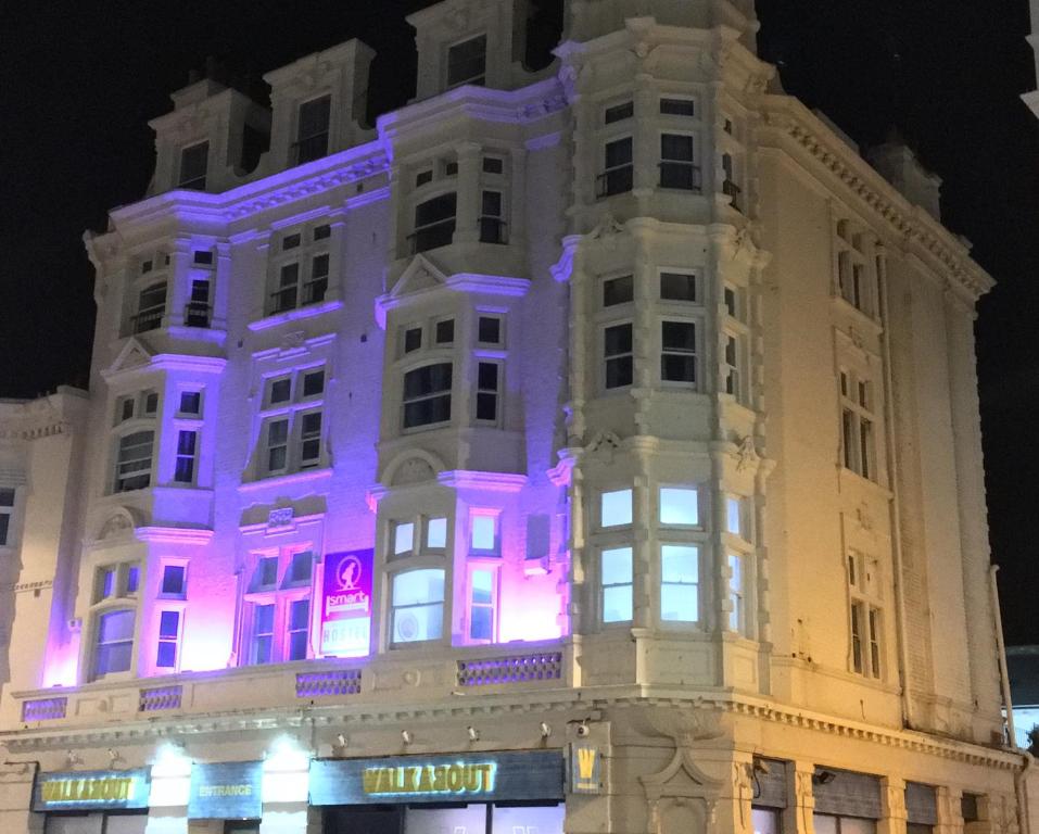 un edificio blanco con luces moradas. en Brighton Beach Inn en Brighton & Hove