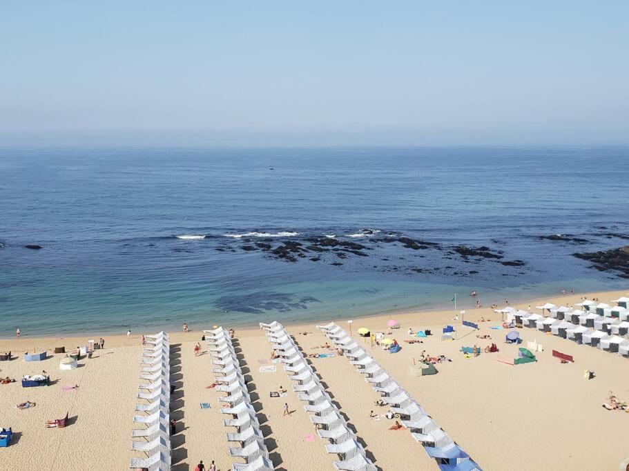 an overhead view of a beach with people and umbrellas at Beach front - sea and sunset views in Póvoa de Varzim