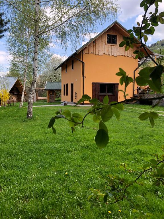 une maison dans un champ d'herbe verte dans l'établissement Pokoje u Adama Grajoka, à Szczawnica