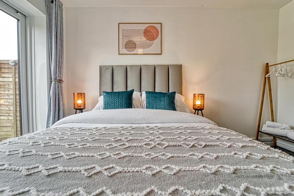 a bedroom with a large bed with blue pillows at Guest Homes - Coney Green in Worcester