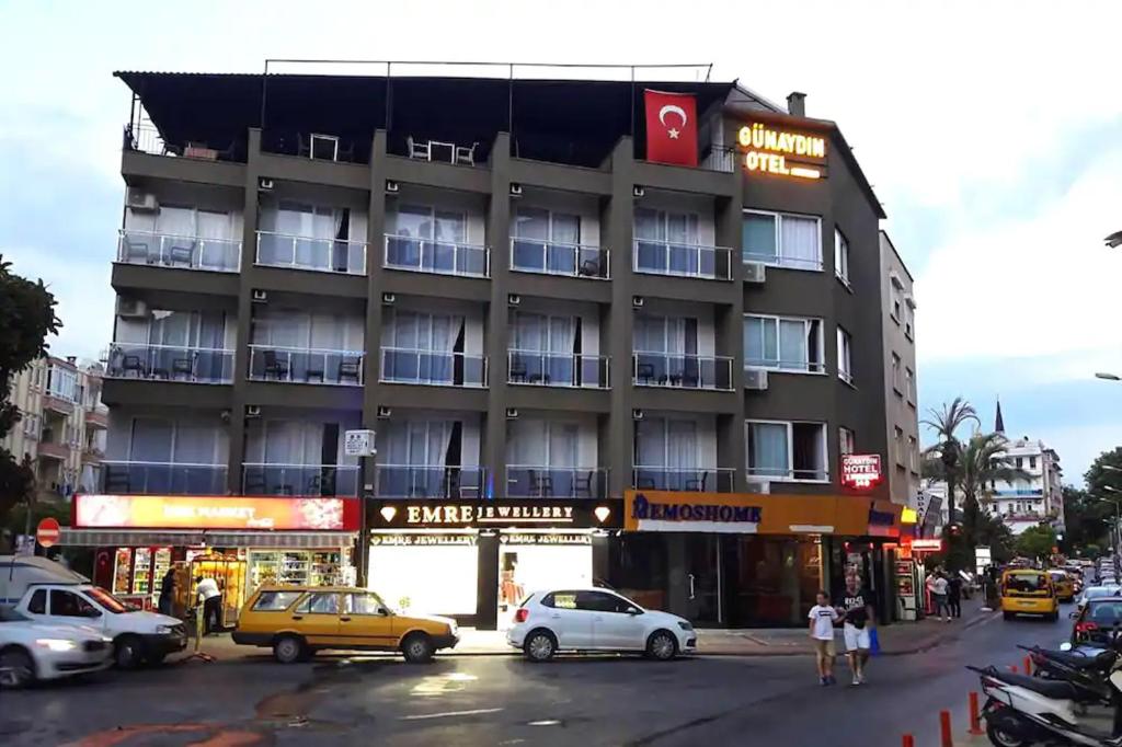 een gebouw waar auto's voor geparkeerd staan bij Günaydın Otel Alanya in Alanya