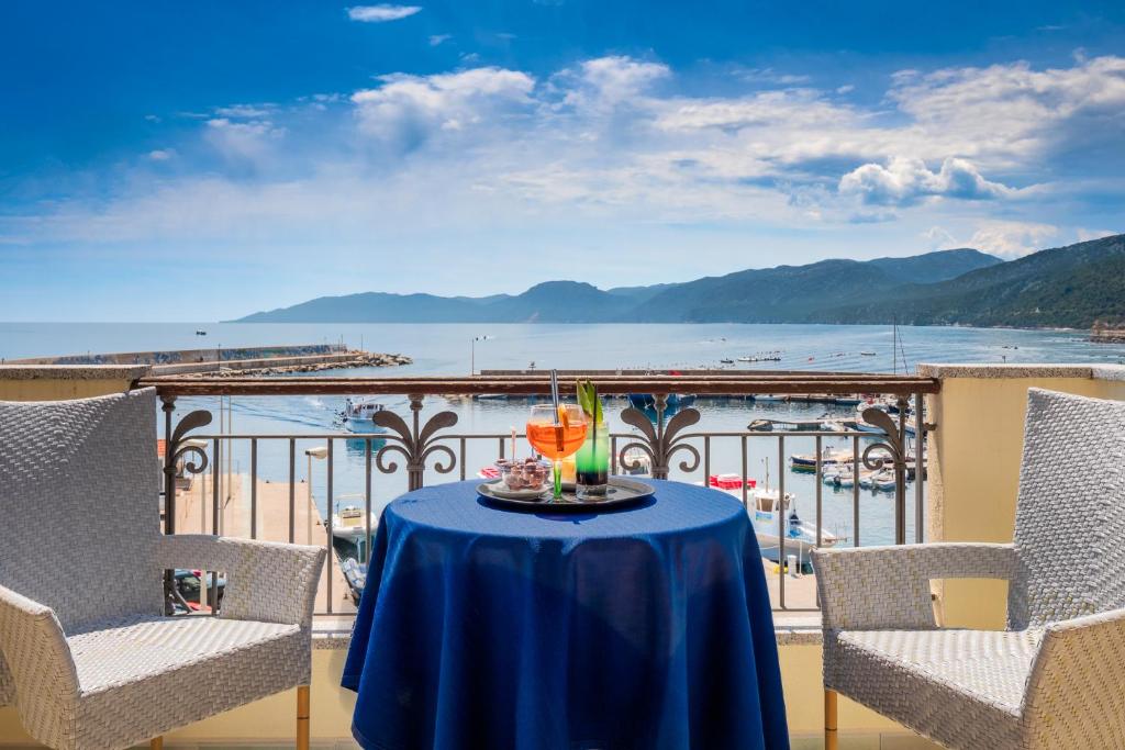 einen Tisch auf einem Balkon mit Blick auf das Wasser in der Unterkunft Il Nuovo Gabbiano in Cala Gonone