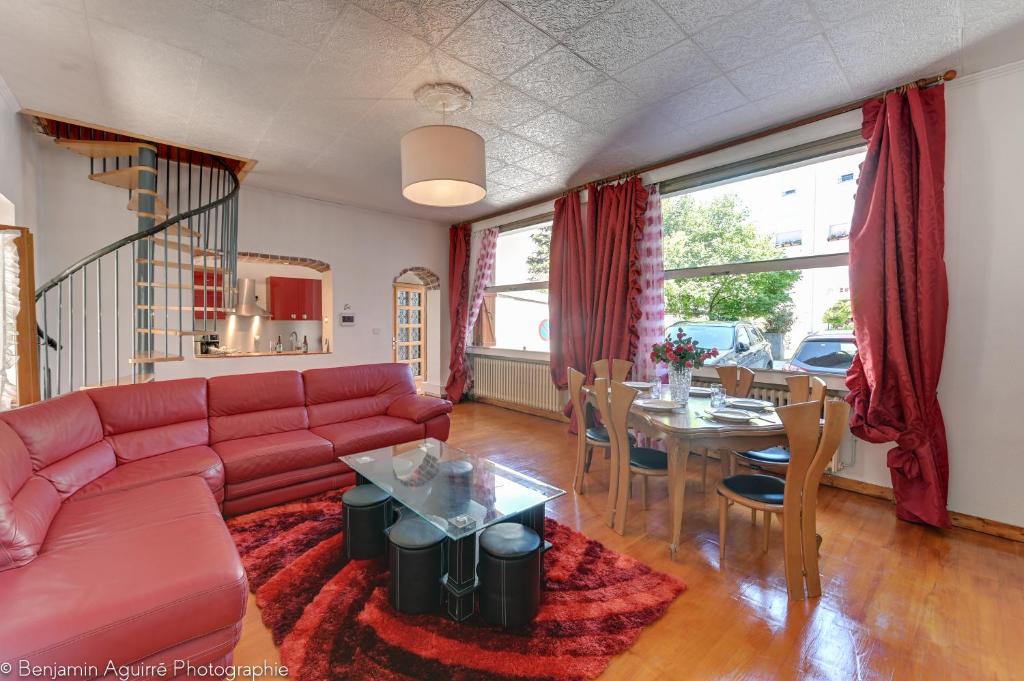 uma sala de estar com um sofá vermelho e uma mesa em Villa Lamartine em Aix-les-Bains