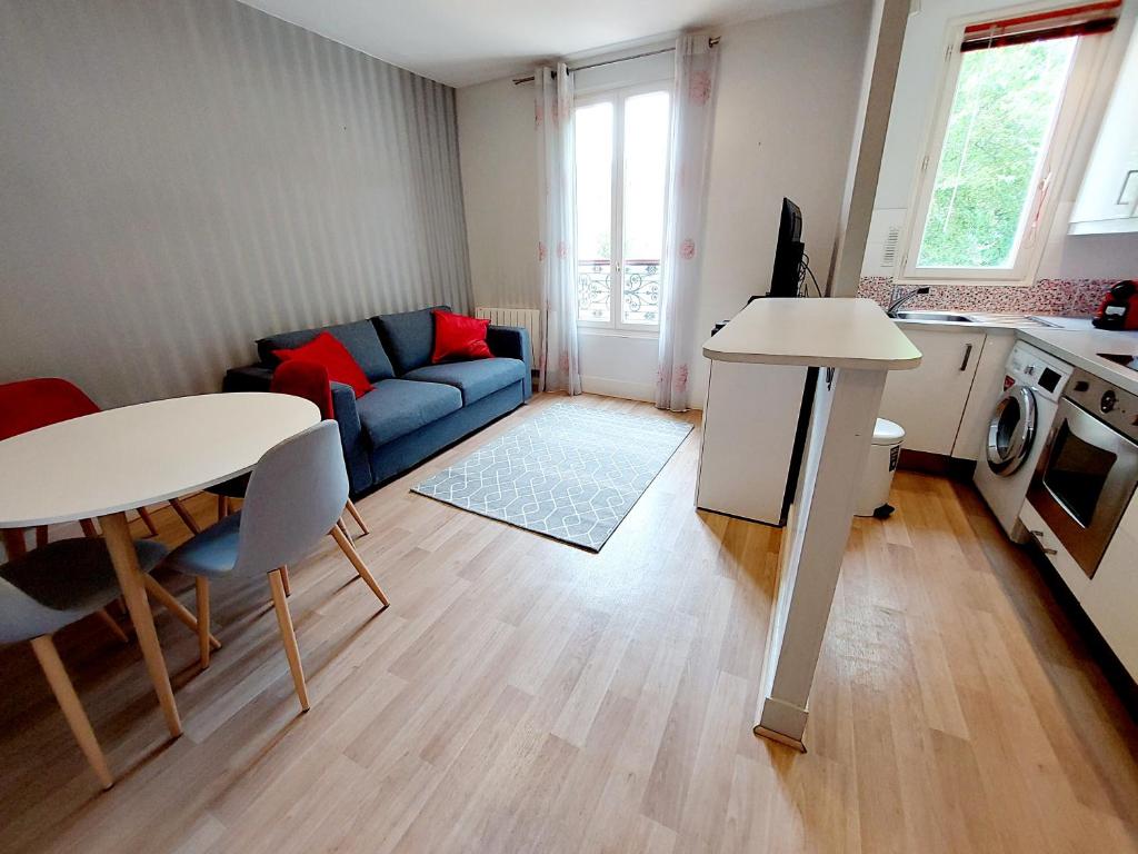 sala de estar con sofá azul y mesa en F2 Entre Paris et Eurodisney 5 min à pied gare en Le Perreux-Sur-Marne