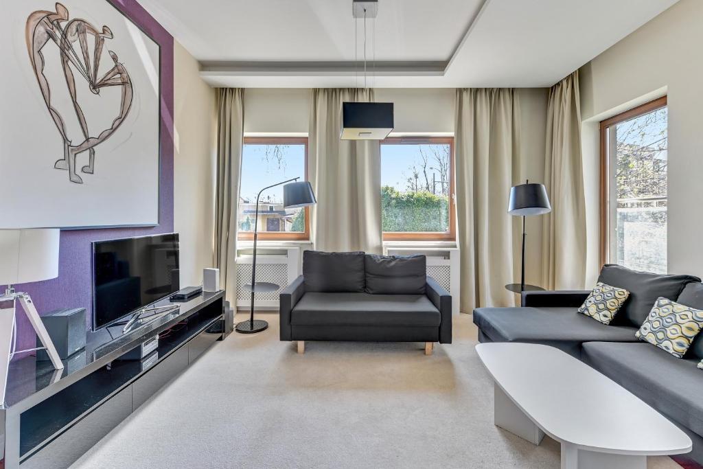 a living room with a couch and a tv at Executive Apartment with Sauna by Grand Apartments in Sopot