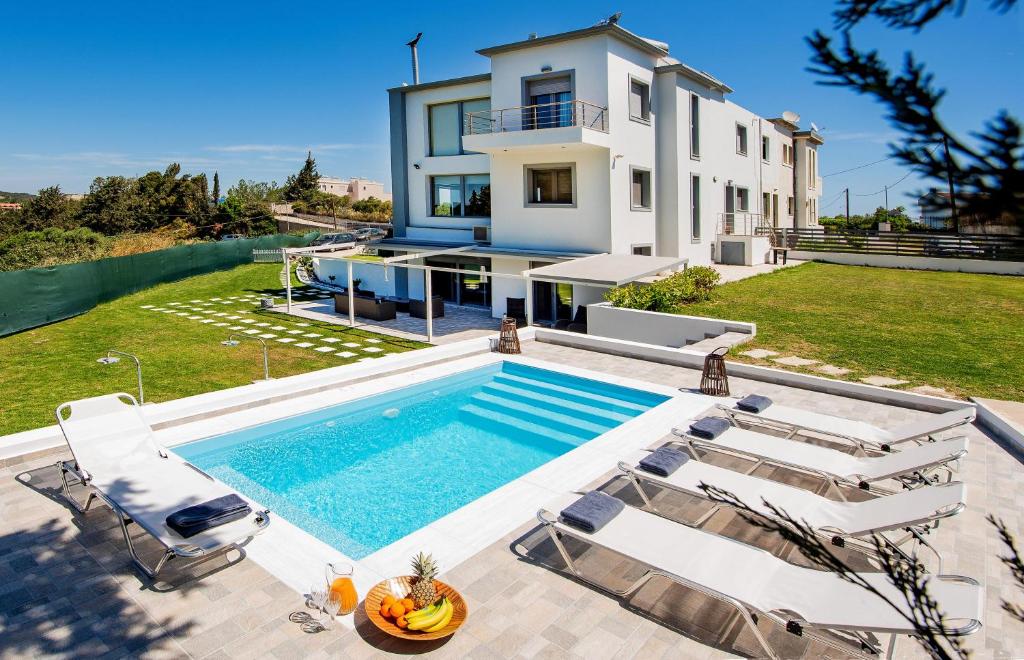 a villa with a swimming pool and a house at Dias Luxury Villa in Koskinou