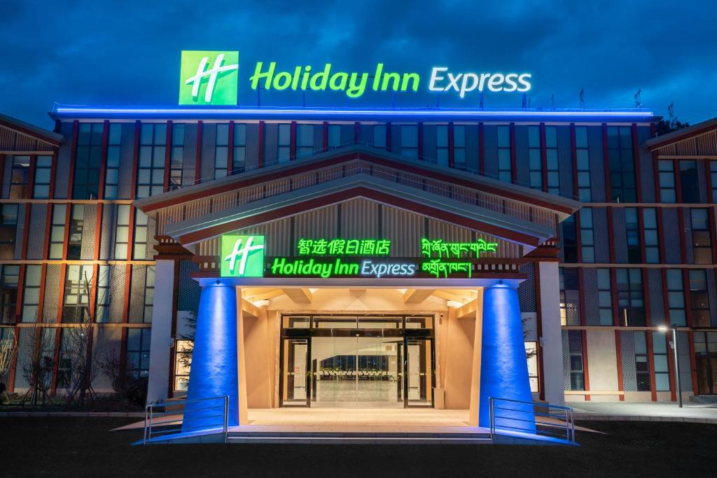 Holiday Inn Express Linzhi Airport, an IHG Hotel في نينغتشي: مبنى فيه لافته مكتوب فيها هوليدي ان سريع
