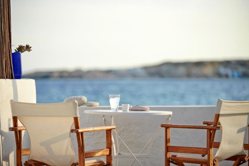 a table and chairs with a view of the water at Thalassa Beach House in Kimolos