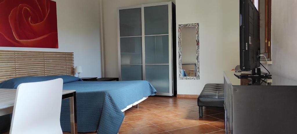 sypialnia z niebieskim łóżkiem i telewizorem w obiekcie Villa Smeraldo Roma w mieście Infernetto