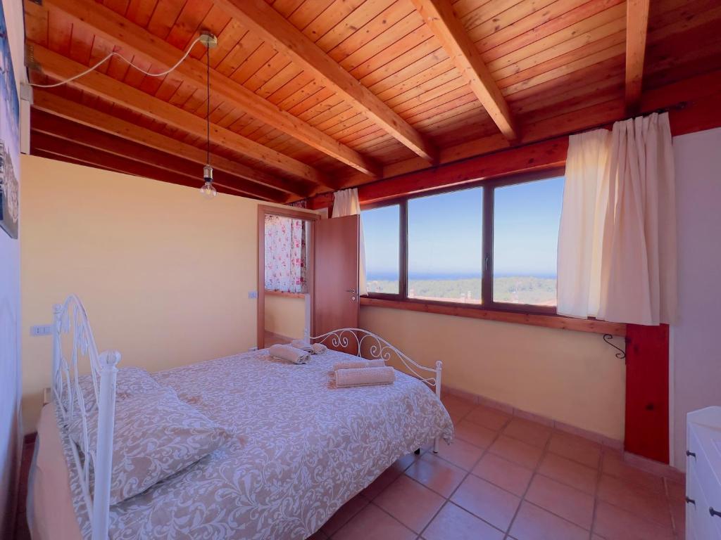 een slaapkamer met een bed en een groot raam bij Appartamento con vista sul Gargano in Vico del Gargano