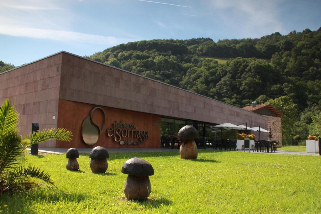 a building with a group of animals in the grass at Balneario Elgorriaga in Elgorriaga