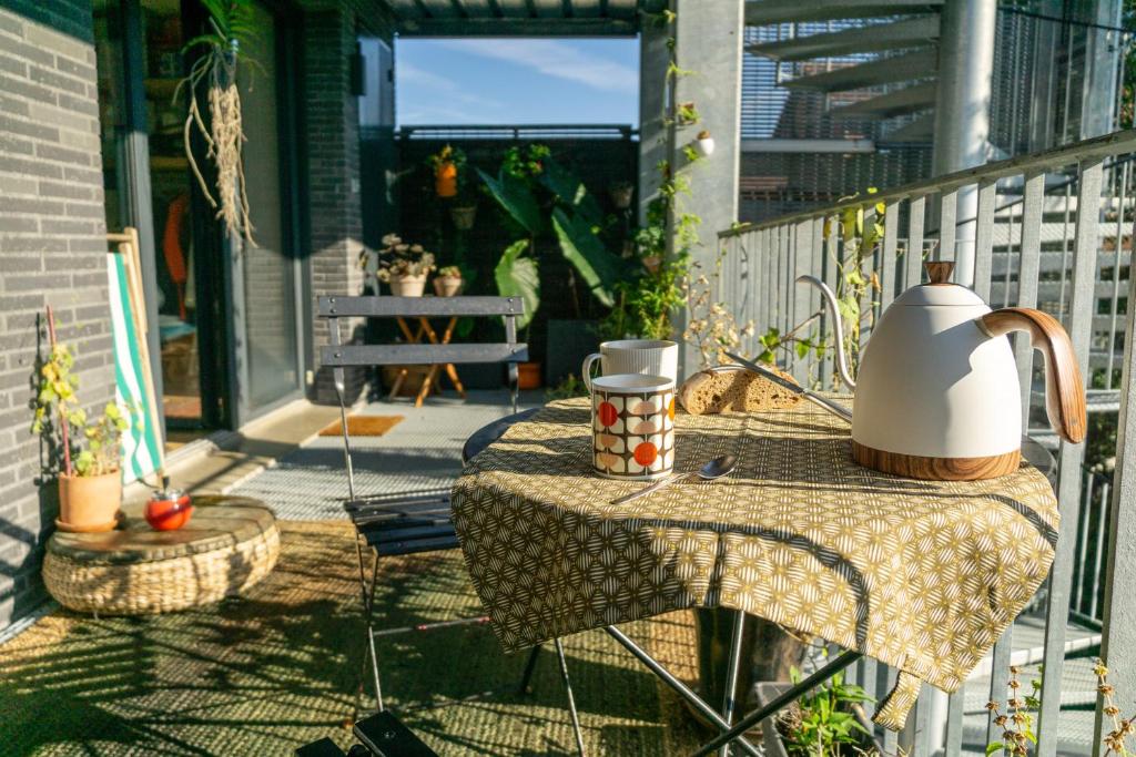 un bollitore per tè su un tavolo sul balcone di Chambre d'hôtes de charme à Montreuil-Paris a Montreuil