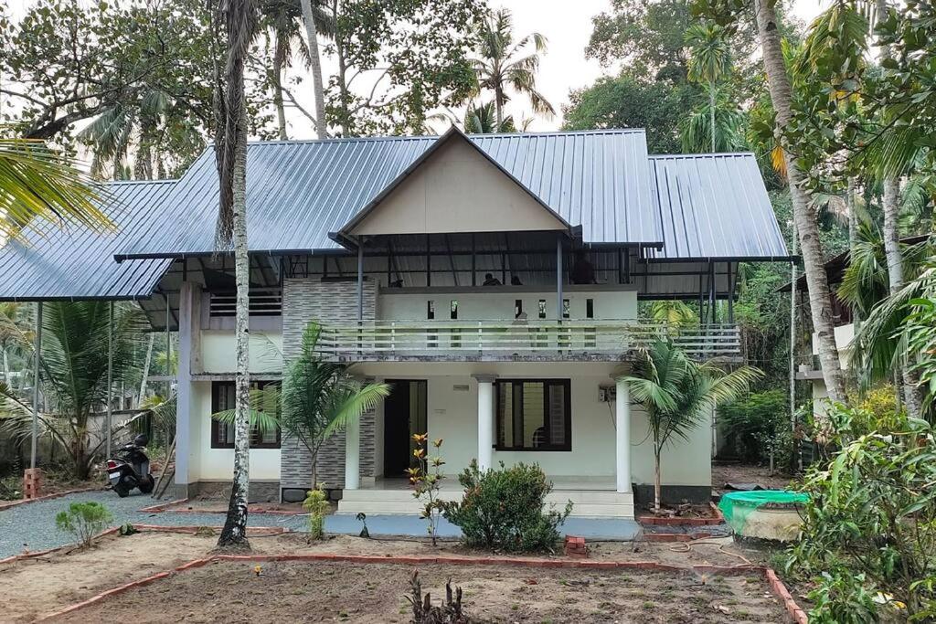 una casa blanca con techo de metal en Viva la Veda, en Karunāgapalli