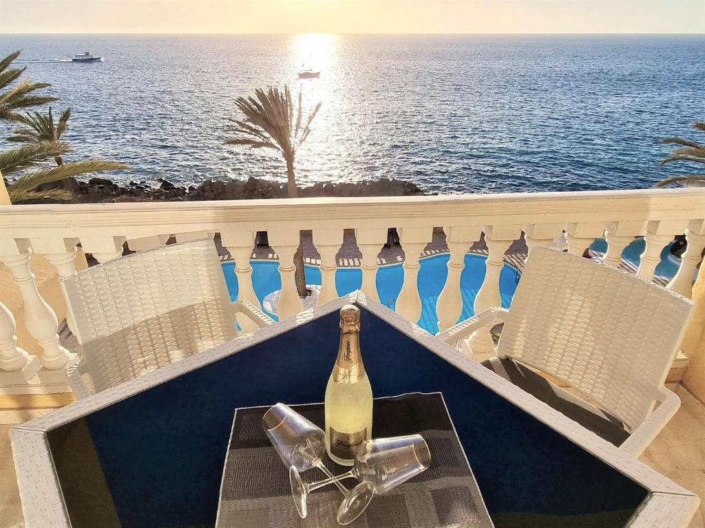 een fles wijn op een tafel op een balkon bij Sunset Ocean in Arguineguín