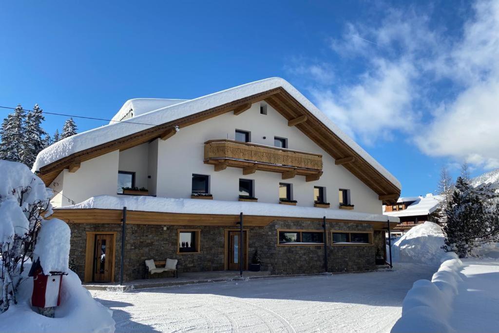 un gran edificio con nieve en el suelo en Appartements Ausserladscheider, en Leutasch