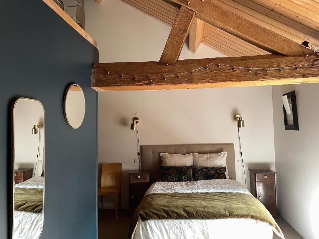 1 dormitorio con 2 camas y techo de madera en Le Clos de Miribel, en Givry