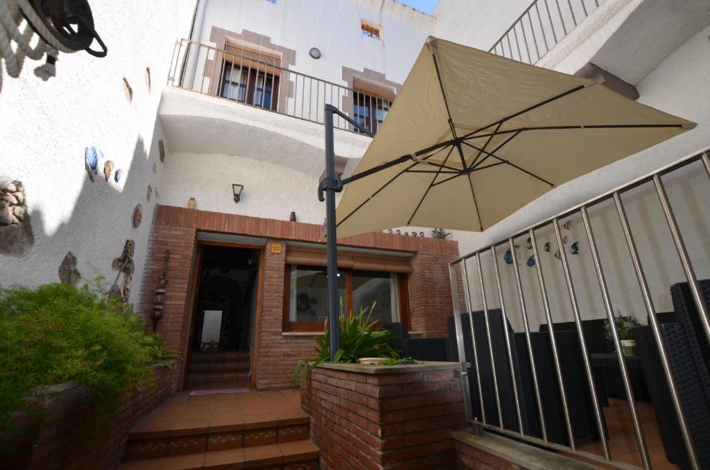 a large umbrella on the front of a house at LUXURY HOUSE 8 PERSONS FRONT THE BEACH BLANES COSTA BRAVA in Blanes