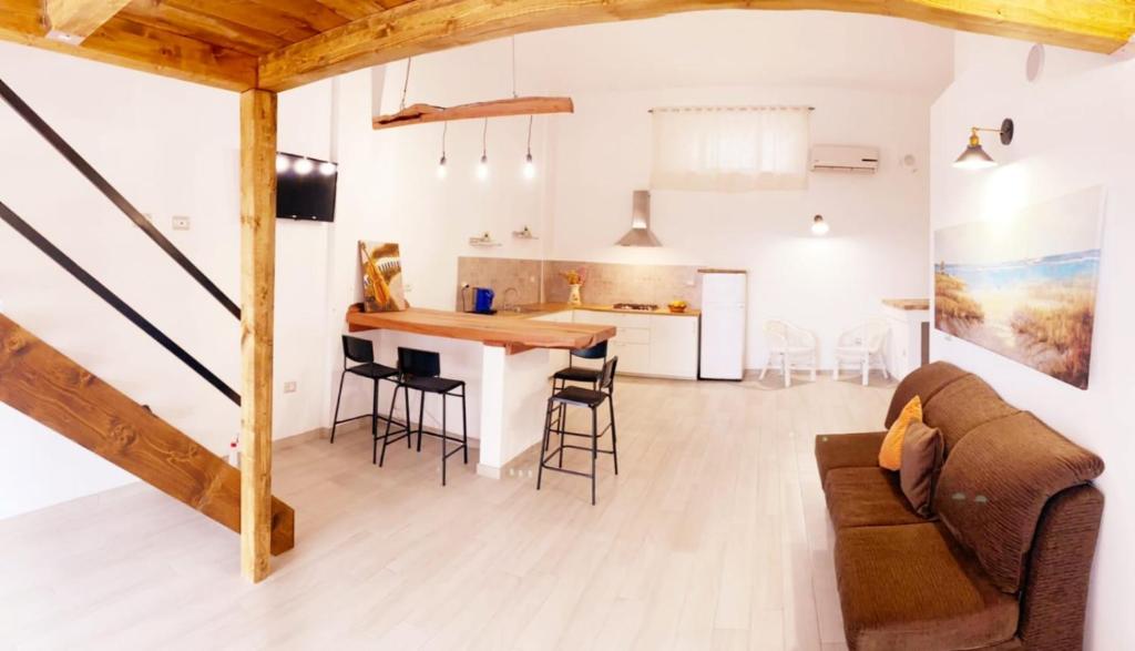 een woonkamer en een keuken met een bank en een tafel bij Casa Vacanza Grifone in Zaccanopoli