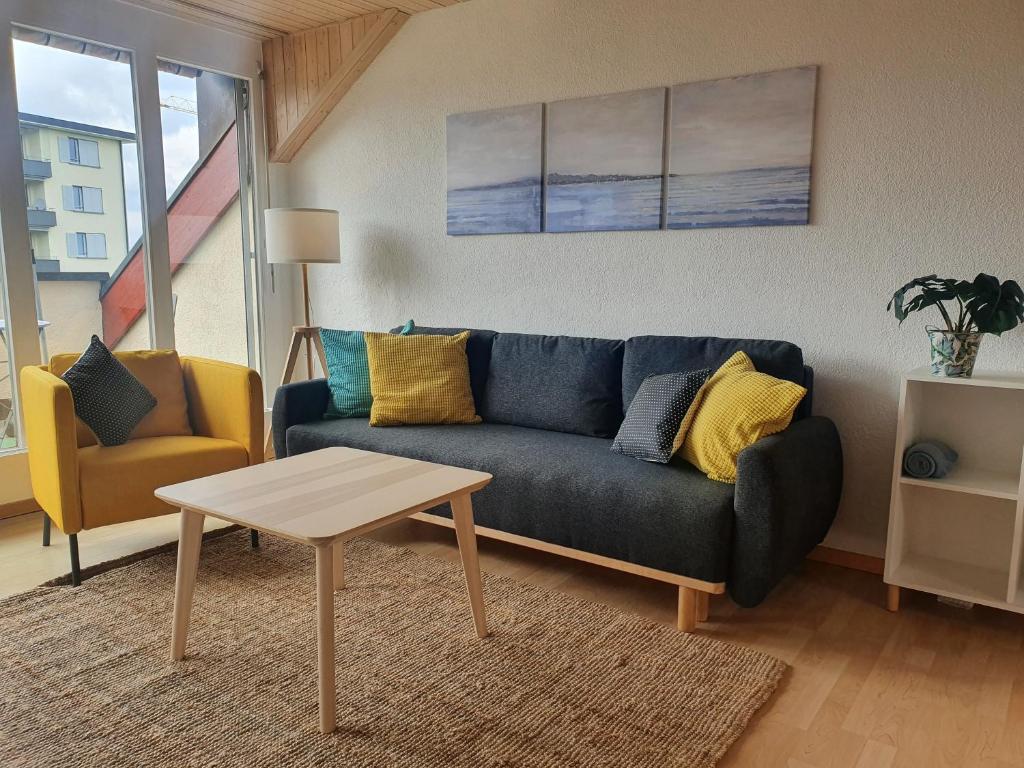 - un salon avec un canapé bleu et une table dans l'établissement Ferienwohnung mit Ausblick, à Kreuzlingen